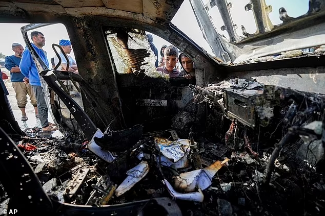 Des personnes inspectent le site où les employés de World Central Kitchen ont été tués à Deir al-Balah, dans la bande de Gaza, le mardi 2 avril 2024.