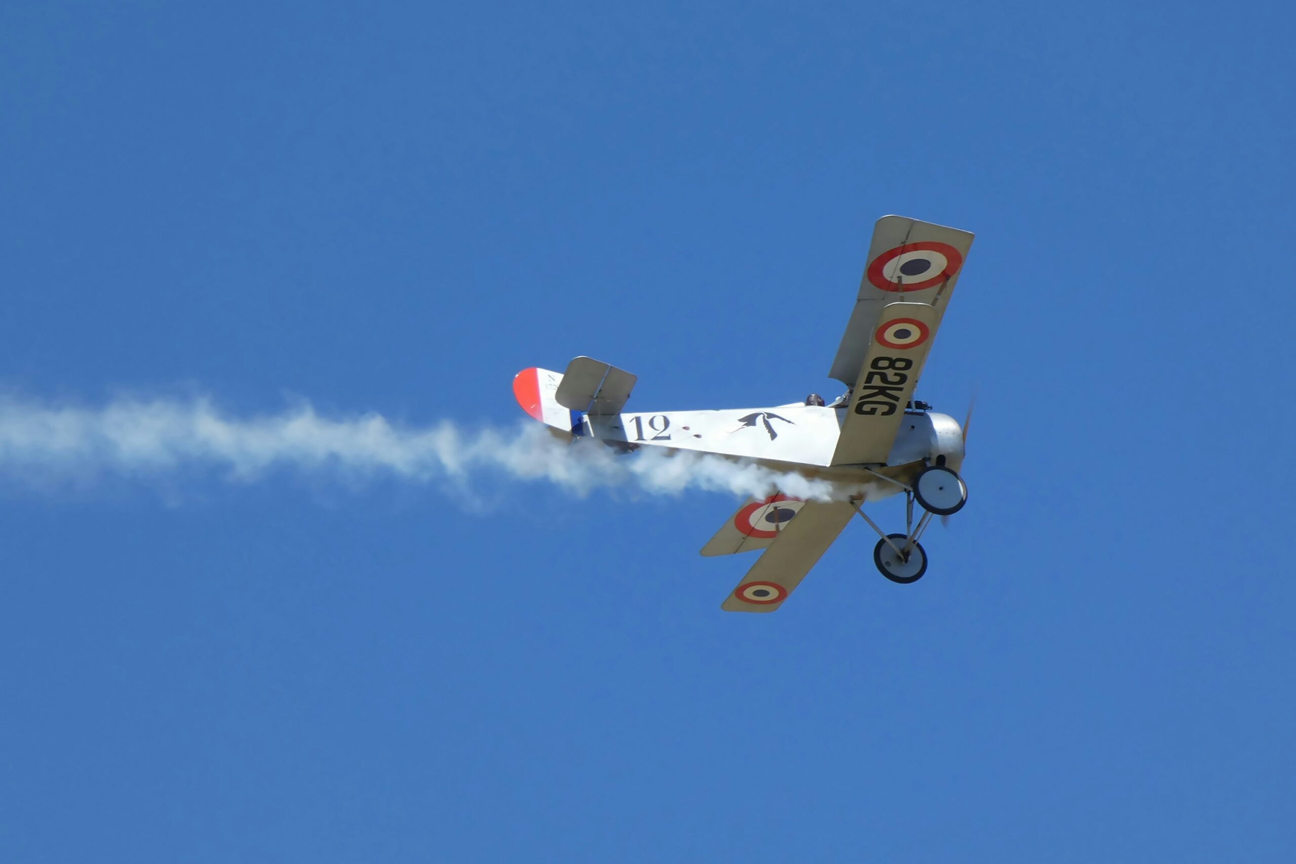 a small airplane flying through a blue sky