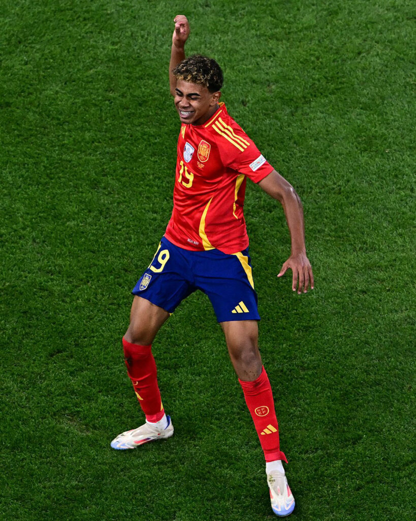 Il a ébloui le monde entier par son talent lors de la victoire de l'Espagne contre la France (2-1), mardi 9 juillet en demi-finale de l'Euro. Du haut de ses 16 ans, l'attaquant espagnol Lamine Yamal est devenu le plus jeune buteur dans l'histoire des grandes compétitions internationales. Le prodige du FC Barcelone est la grande révélation de cet Euro et fait la fierté du quartier populaire où il a grandi, à 30 kilomètres au nord de Barcelone, à Mataro. Franceinfo s'est rendu sur place.
Euro 2024 : "Démasqués", "Adieu l'Euro", "Une leçon d'espagnol"... La revue de presse de l'élimination des Bleus face à l'EspagneSur la terrasse du bar Imperial, au pied des immeubles d’un quartier populaire de Mataro, Abdulah, Abdeslam ou encore Tarik ont du mal à y croire. Ils savourent la victoire de l’Espagne et ce but splendide de Lamine Yamal, d'une frappe enroulée en pleine lucarne pour l'égalisation (21e), de ce gamin de 16 ans qu'ils ont vu grandir. "C'est merveilleux ! Lamine Yamal est un très grand joueur, c'était génial. Grâce à lui, on est tellement heureux !", s'écrient-ils en chœur.
La moitié des habitants vivent sous le seuil de pauvreté
Le père et la grand-mère du jeune attaquant, originaire du nord du Maroc, vivent toujours dans ce quartier de Rocafonda, qui a accueilli des travailleurs du sud de l’Espagne dans les années 1960 avant de recevoir des Marocains. Raquel, une voisine de la famille, a passé une belle soirée. "Tout le monde est sorti dans la rue pour fêter la victoire. Ça me fait plaisir car on parle souvent de Mataro pour de mauvaises raisons. Or là, c'est quelque chose de positif !", assure-t-elle.
Le quartier de Rocafonda, situé à 15 minutes à pied du centre-ville et de la plage, n’est pas un ghetto. Les rues sont bien entretenues mais près de la moitié de ses habitants vit sous le seuil de pauvreté. Le jeune Lamine Yamal est donc un exemple pour beaucoup d'habitants, particulièrement les jeunes. "Il a beaucoup d'amis et de famille ici, tout le monde le connaît. C'est une grande fierté", ajoute Tarik, en français.
Le jeune footballeur n’a pas oublié son quartier. Il y revient souvent et dès qu’il marque, il dessine avec ses doigts le chiffre 304, soit le code postal de Rocafonda.