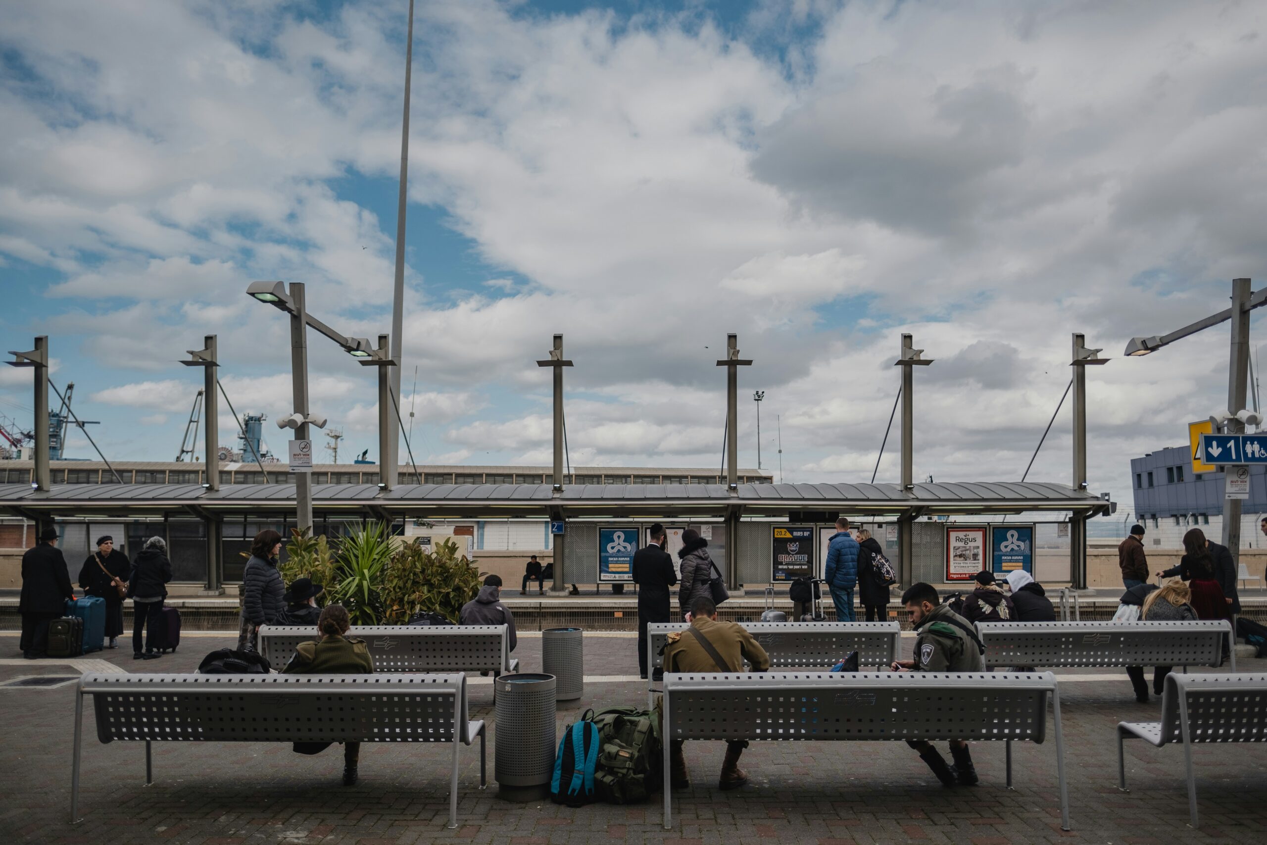 a group of people sitting on top of metal benches