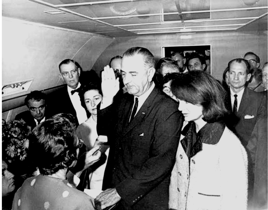 22 novembre 1963. Lyndon Baines Johnson (55 ans) prête serment à bord de l’Air Force One, sur le tarmac de l’aéroport de Dallas. Jackie Kennedy est à ses côtés. Le président américain John Fitzgerald Kennedy (JFK) est mort deux heures auparavant. Il incombe désormais au vice-président, en poste depuis 1961, de reprendre la charge du pays. Vice-président effacé, l’homme est considéré comme un politicien sur la touche mais néanmoins jugé excellent dans les situations d’urgence. À la Maison Blanche, il va se révéler énergique et ambivalent, promettant la Grande Société et plongeant aussi le pays dans la guerre du Vietnam.